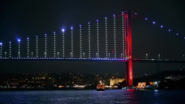 İstanbul, Türkiye 'de İstanbul Köprüsü' nün gece manzarası. Yüzen bir gemiden görüntü, aydınlanma, köprü vagonlarında hareket.