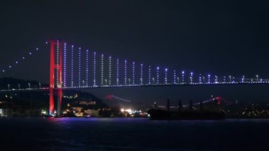 İstanbul, Türkiye 'de İstanbul Köprüsü' nün gece manzarası. Yüzen bir gemiden görüntü, aydınlanma, köprü vagonlarında hareket.