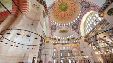 İstanbul, Türkiye 'deki Süleyman Camii' nin iç manzarası. Bir sürü aydınlatma, boyanmış tavan.