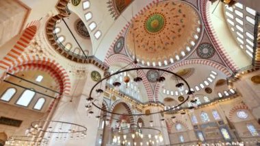 İstanbul, Türkiye 'deki Süleyman Camii' nin iç manzarası. Bir sürü aydınlatma, boyanmış tavan.