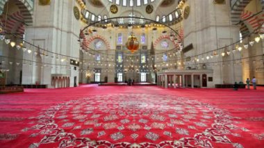İstanbul, Türkiye 'deki Süleyman Camii' nin iç manzarası. Bir sürü aydınlatma, boyanmış tavan, kırmızı halı.