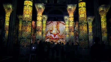 Türkiye 'nin İstanbul kentindeki Theodosius sarnıçında ışık gösterisi. Bir sürü sütun, alacakaranlıkta resimler, insanlar
