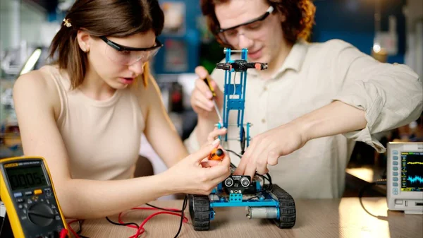Two Young Happy Engineers Fixing Mechanical Robot Car Workshop Using — Stock Photo, Image