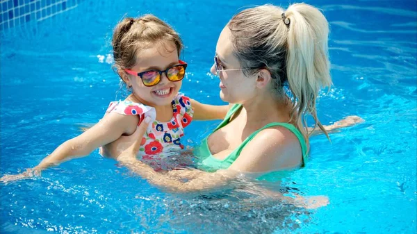 夏にプールで休んで泳ぐ母と娘 — ストック写真