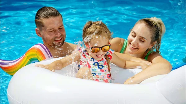 夏にプールで休んで泳ぐ父と娘と母 — ストック写真