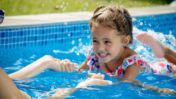 Güneş Gözlüklü Küçük Kız Annesiyle Havuzda Yüzmeyi Öğreniyor — Stok fotoğraf
