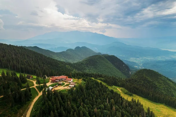 Aerial drone view of Poiana Brasov, Romania. Touristic buildings located on top of the mountain covered with lush forest