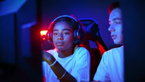 Weiße Jungen Und Schwarze Mädchen Diskutieren Headsets Während Sie Videospiele — Stockvideo