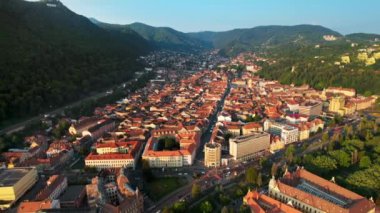 Romanya 'nın Brasov kentindeki hava aracı görüntüsü. Eski binalarla dolu eski şehir merkezi, yeşilliklerle kaplı tepeler