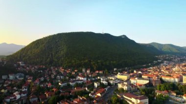 Romanya 'nın Brasov kentindeki hava aracı görüntüsü. Eski binalarla dolu eski şehir merkezi, yeşilliklerle kaplı tepeler