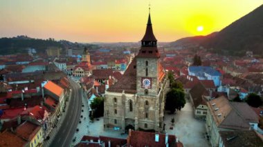 Romanya 'nın başkenti Brasov' un merkezindeki Kara Kilise 'nin hava aracı görüntüsü. Çevresindeki eski binalar, yeşillikli tepeler.