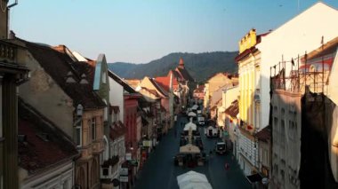 Romanya 'nın güneş doğarken Brasov' un insansız hava aracı görüntüsü. Eski binalar, yayalar, Siyahi Kilise ve tepeleri olan eski şehir merkezi.