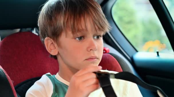 車に座り 子供の安全シートにVrメガネをかけている少年 スローモーション — ストック動画