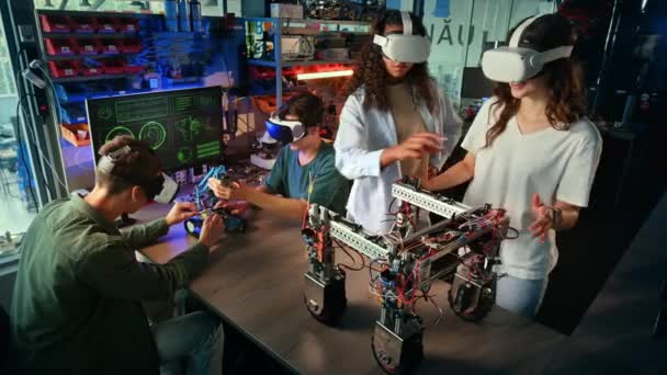 Vrメガネの若者のグループは 実験室でロボット工学の実験を行っています ギャスカリング テーブルの上のロボット — ストック動画