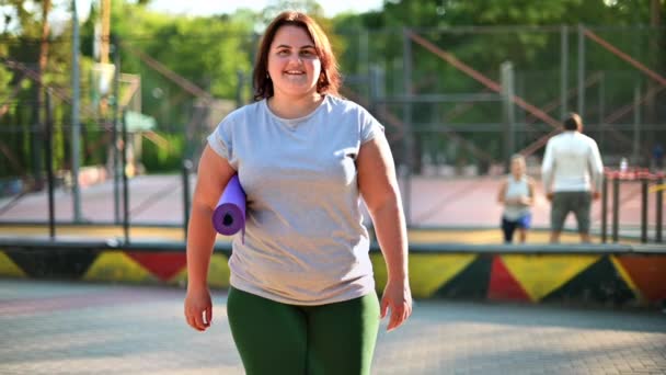 Frau Mit Übergewicht Grauem Shirt Und Leggings Auf Einem Sportplatz — Stockvideo