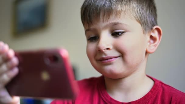 Gülümseyen Sarışın Küçük Çocuk Akıllı Telefondan Video Izliyor — Stok video