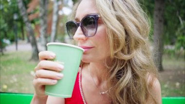 Parkta yeşil çay içen kadın, ağır çekimde.