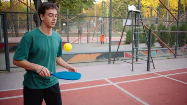 Мальчики Играют Пиклбол Желтым Мячом Синим Веслом Корте — стоковое видео