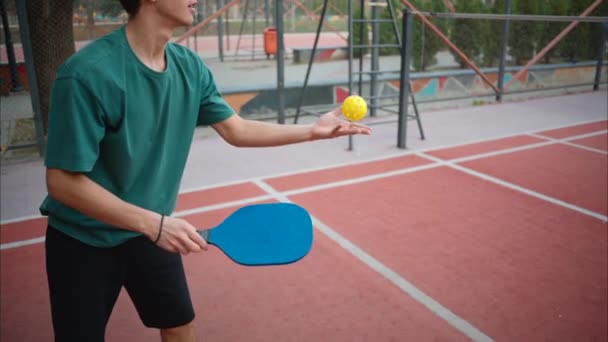 男孩子们在球场上玩黄球和蓝色桨的泡菜球 — 图库视频影像