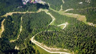 Romanya 'nın Allah Brasov kentinin insansız hava aracı görüntüsü. Dağlara yakın küçük bir kasaba, yemyeşil orman ve yollarla kaplı.