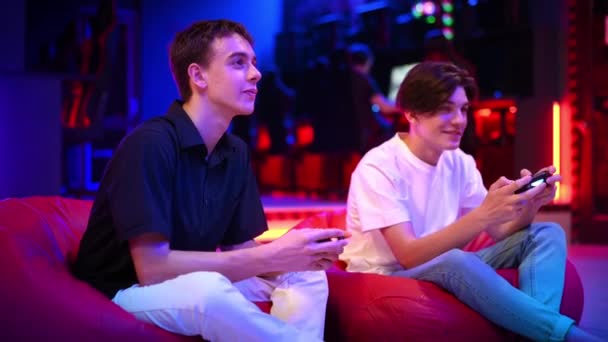 Két Tini Barát Játékkonzolon Játszik Gamepad Használva Beszélgetnek Nevetnek Miközben — Stock videók