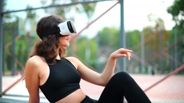 Leende Kvinna Som Använder Headset Träningsoverall Sittande Yogamattan Idrottsplan Park — Stockvideo