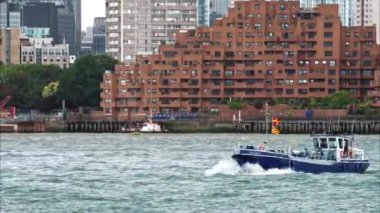 Thames nehrinde yüzen bir teknenin yakın görüntüsü, Londra 'nın arka planında bulunan yerleşim binaları, İngiltere