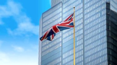 Londra 'nın arka planında gökdelen olan Birleşik Krallık bayrağının yakın görüntüsü