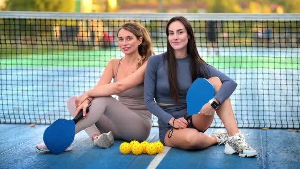 Dos Mujeres Sonrientes Trajes Deportivos Posando Con Pelotas Raquetas Para — Vídeo de stock