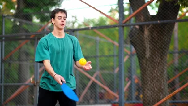 Молодой Парень Играет Пиклбол Бросает Мяч Ракеткой Открытой Площадке Медленное — стоковое видео