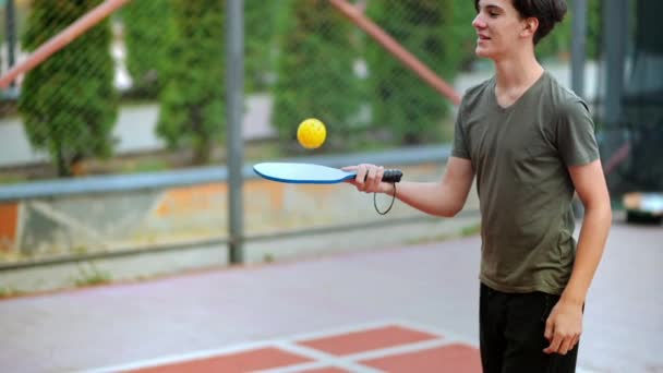 Молодой Парень Играет Пиклбол Набивает Мяч Ракеткой Открытой Площадке Медленное — стоковое видео