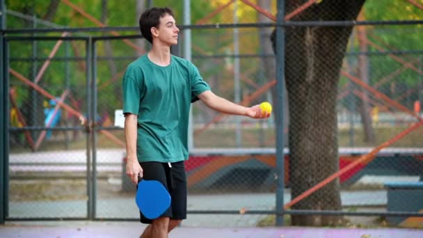 ピックルボールをやっている若者は 屋外のコートでラケットでボールピッチを作る スローモーション — ストック動画