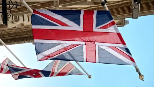 Nära Vertikal Över Flaggor Storbritannien Ligger Fasaden Byggnad London Centrum — Stockvideo