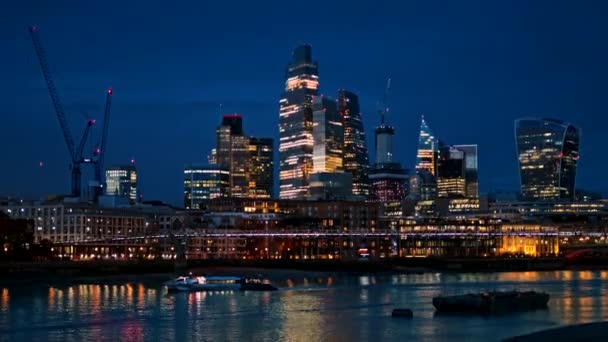 伦敦市中心的城市景观在晚上 城市地区的摩天大楼 泰晤士河 上面有千禧桥和漂浮的小船 照明充足 — 图库视频影像