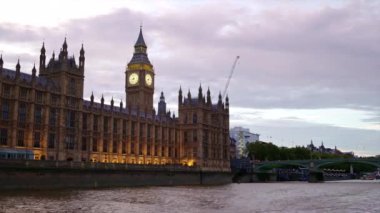 Günbatımında Thames Nehri 'nde yüzen bir tekneden Londra manzarası, İngiltere. Westminster Sarayı ve Elizabeth Kulesi