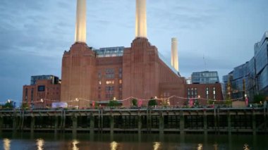 Londra, İngiltere 'de gün batımında Thames Nehri' nde yüzen bir tekneden Battersea Enerji İstasyonu 'nun görüntüsü