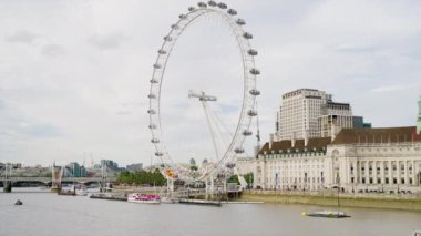 Londra şehir merkezindeki Londra Göz dönme dolabının görüntüsü, İngiltere. Kraliçe 'nin yürüyüşü ve Thames nehri üzerinde yüzen tekne, arka planda şehir manzarası