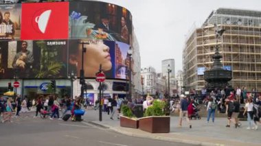 LONDRA, BİRLİK KINGDOM - 11 Ağustos 2023: Piccadilly Sirki, Shaftesbury Memorial Fountain yakınlarında insanlar, hareket halindeki arabalar, klasik binalar ve reklam ekranları.