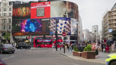 LONDRA, BİRLİK KINGDOM - 11 Ağustos 2023: Piccadilly Sirki 'nde birden fazla yürüyen insan ve hareket halindeki arabalar, klasik binalar ve reklam ekranları