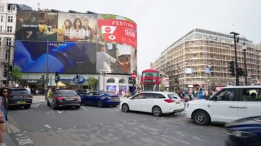 LONDRA, BİRLİK KINGDOM - 11 Ağustos 2023: Piccadilly Sirki 'nde birden fazla yürüyen insan ve hareket halindeki arabalar, klasik binalar ve reklam ekranları