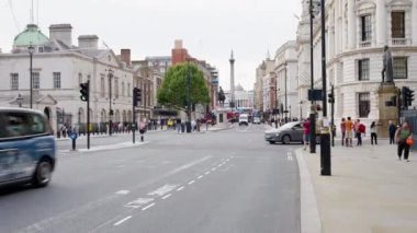 LONDRA, BİRLİK KINGDOM - 11 Ağustos 2023: Whitehall Caddesi 'nde yürüyen insanlar, klasik binalar ve hareket halindeki arabalar, Nelson' s Column ve Trafalgar Meydanı