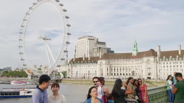 2023年8月11日 从威斯敏斯特桥观看伦敦风眼摩天轮 泰晤士河上有一艘载客的浮船 — 图库视频影像