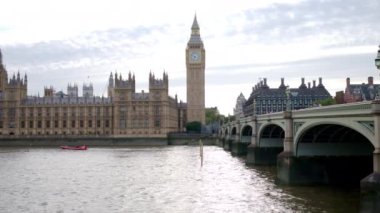 Londra, UNITED KINGDOM - 11 Ağustos 2023: Westminster Sarayı, Köprü ve şehir merkezindeki Elizabeth Kulesi manzarası. Yüzen tekneli Thames nehri