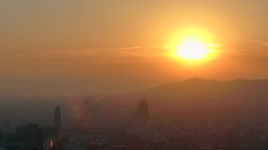 Gün batımında turuncu güneşle Barselona şehrinin hava aracı görüntüsü