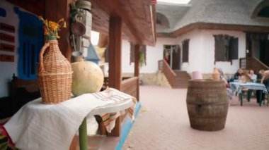 Geleneksel elementler ve Moldova 'daki bir köydeki şarap imalathanesinde dinlenen insanlar. Ulusal şarap ve havlu, geleneksel evler. Yavaş çekim