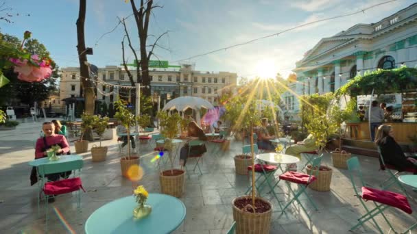 シスナウ モルドバ October 2023 夕暮れの市街地のエミネシク広場を表示しています カフェ デコレーション 緑の近くに複数の休息の人々 — ストック動画