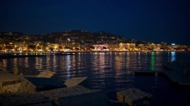 Akdeniz kıyısı Cannes, Fransa. Deniz kıyısında aydınlık binalar ve yansımalar var.