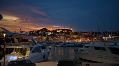 CANNES, FRANCE - 23 EYLÜL 2023: gece demirli yatlarla Cannes limanının manzarası. Arkaplanda şehir manzarası, aydınlatma
