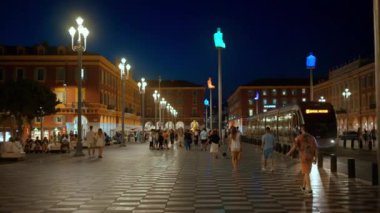 Güzel, Fransa - 25 Eylül 2023: akşam Massena 'da. Birden fazla yürüyen insan, klasik binalar ve aydınlatma.