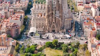 Şehir merkezindeki Sagrada Familia 'nın hava aracı görüntüsü. Çevredeki insanlar ve yerleşim bölgeleri, yeşillik, Barselona, İspanya